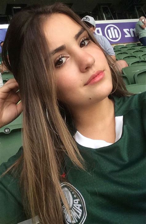 A Girl With Long Hair Sitting In The Stands At A Baseball Game Wearing