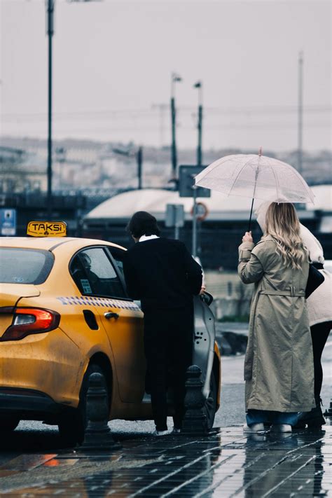 Happy ethnic man with backpack hailing taxi on streetFree Stock Photo