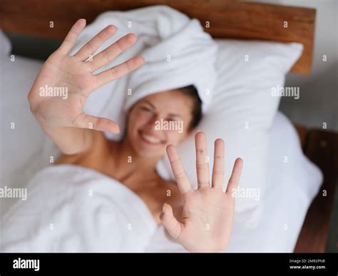 Cute Shy Woman Lies On The Bed After A Shower With A Towel On Her Head In The Bedroom Smiles