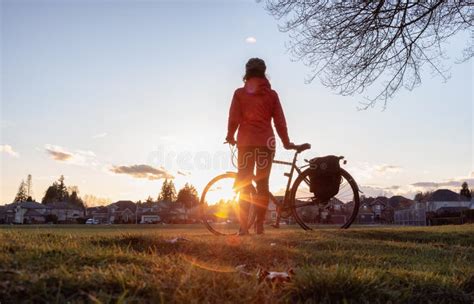 Adventurous Woman Standing With A Bicycle At A Park In Modery City