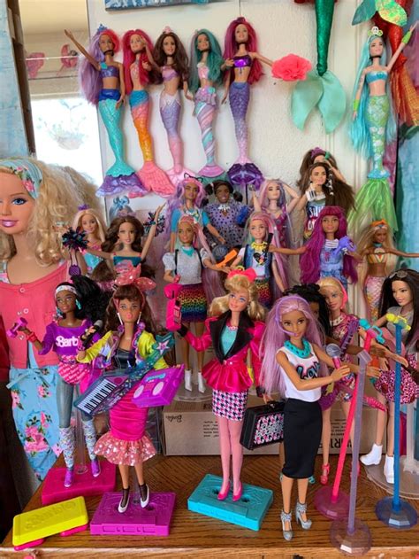 many barbie dolls are lined up in a room