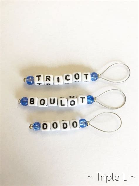 Three White And Blue Beaded Earrings With The Words Tricott Bouliot On Them