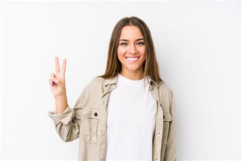 Premium Photo Young Woman Showing Victory Sign And Smiling Broadly