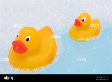 Group Of Yellow Rubber Ducks In Bath Filled Blue Bubble Bath Stock