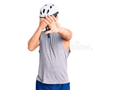 Young Handsome Man Wearing Bike Helmet Covering Eyes With Hands And