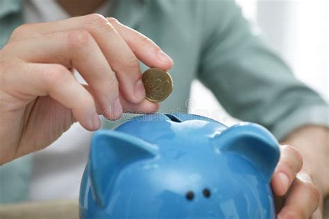 Man Putting Coin Into Piggy Bank Stock Photo Image Of Person Piggy