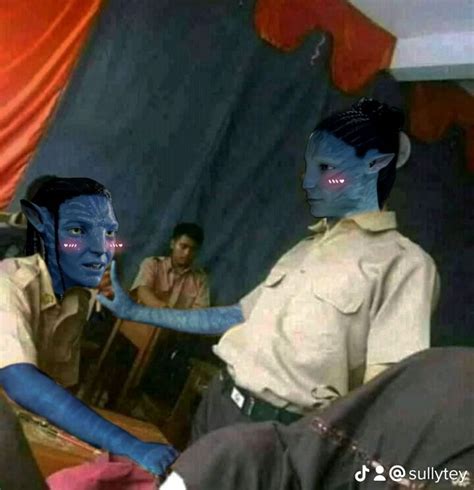 Two People With Blue Painted Faces Sitting In Front Of A Mirror