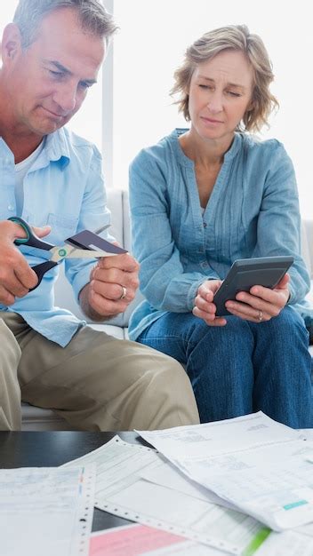 Premium Photo Wife Watching Her Husband Cut Credit Card In Half