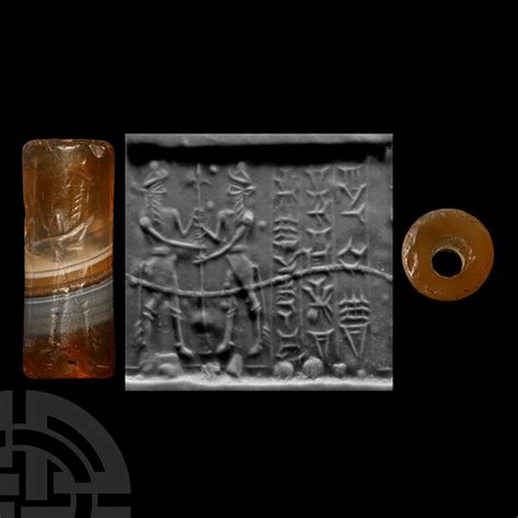 At Auction BABYLONIAN CYLINDER SEAL WITH KING AND BULL MEN