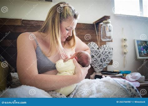 Mother Breastfeeding Her Newborn Baby At Home After The Hospital Stock