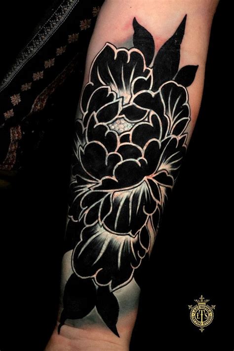 a black and white flower tattoo on the arm