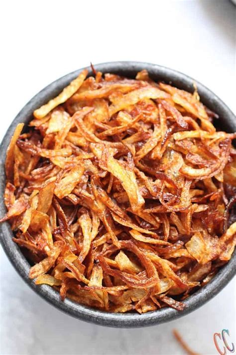 A Bowl Filled With Fried Food Sitting On Top Of A White Countertop Next