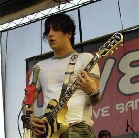 A Man Holding A Yellow Guitar On Top Of A Stage With Other People In