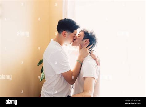 Two Gay Men Wearing White T Shirts Romantically Kissing On The Mouth LGBT Relationship Stock