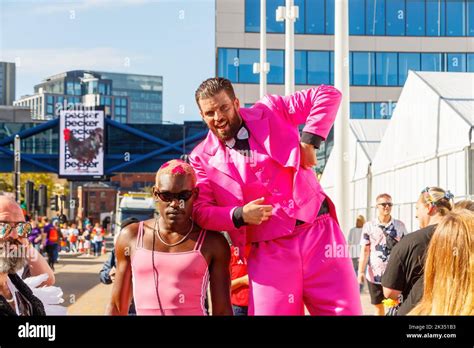Black Skinned Man Wearing Pink Leotard With Bearded Man In Suit On Stilts Gay Pride Parade
