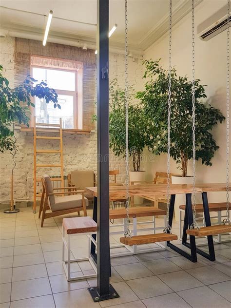 Cozy Interior of a Modern Cafe in Vintage Style, with Wooden Tables and Swings on Chains ...