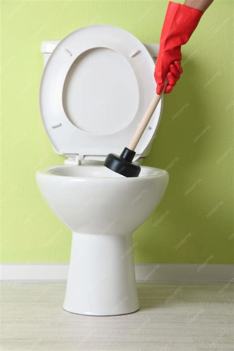 Premium Photo Woman Uses A Plunger To Unclog A Toilet Bowl In A Bathroom