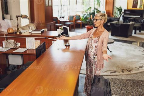 Mature woman comes to the hotel at the reception. She is tired of