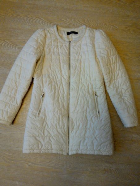 Нарядная удлиненная куртка бело-кремового цвета. Застежка и два боковых ...