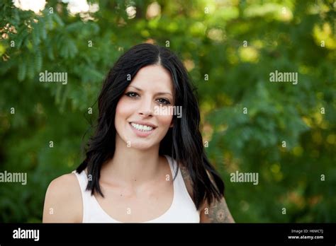Beautiful Brunette Girl Relaxing In The Park Wiht Many Plants Of Background Stock Photo Alamy