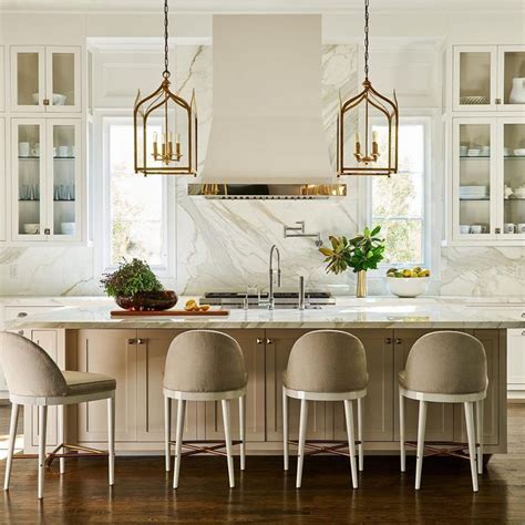 A crisp white kitchen with touches of gold and stunning marblework by ...