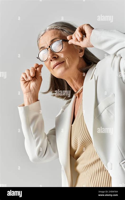 A Beautiful Mature Woman Showcases Her Elegance In A Tailored White Suit Exuding Confidence And