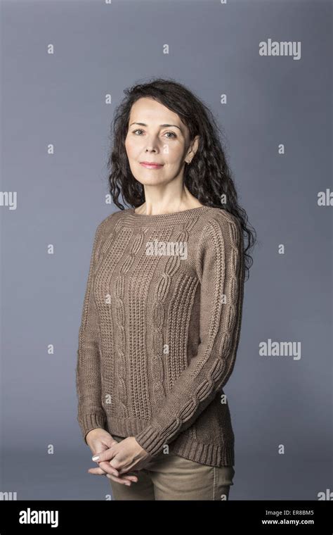Portrait Of Happy Mature Woman Standing Hands Clasped Over Gray Background Stock Photo Alamy