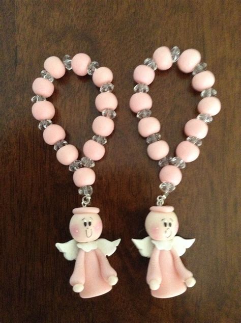 Two Pink Beads With Angel Charms Attached To Them