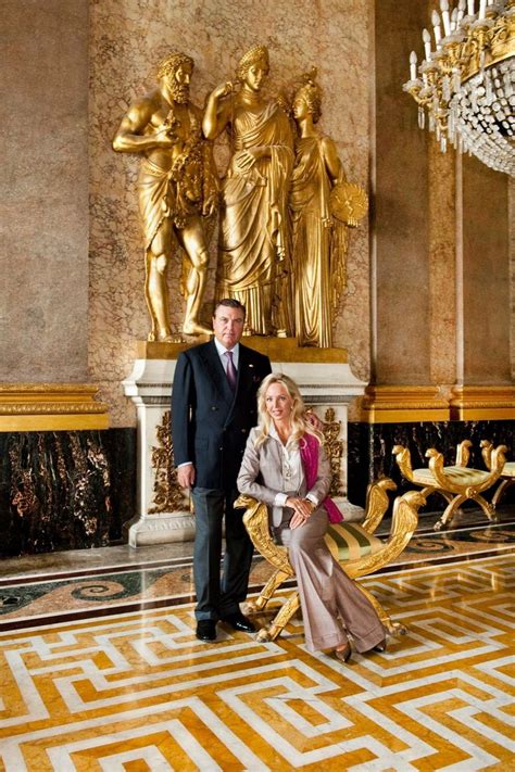 A Man And Woman Posing For A Photo In Front Of A Golden Statue With