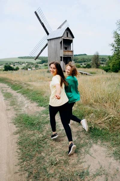 Happy Couple Run In The Field Near The Mill Girlfriends Run Together Across The Field Brunette