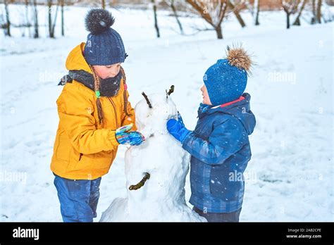 Les Enfants Font Un Bonhomme De Neige Banque De Photographies Et D