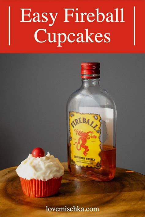 A Cupcake Sitting On Top Of A Wooden Table Next To A Bottle Of Fireball