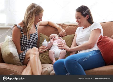 Loving Female Same Sex Couple Cuddling Baby Daughter Sofa Home Stock Photo Monkeybusiness