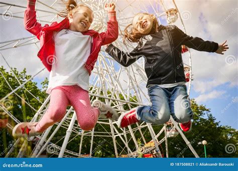 Deux Filles Samusent Dans Le Parc Dattractions Une Roue De Ferris