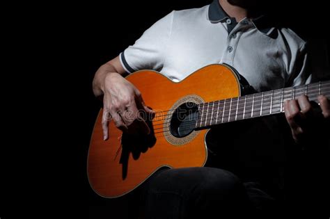 Man Playing An Acoustic Guitar On A Dark Background Playing Guitar