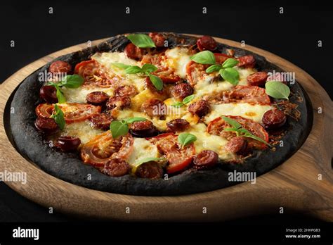 Black Pizza With Tomatoes Sausages Mozzarella And Basil Dough With