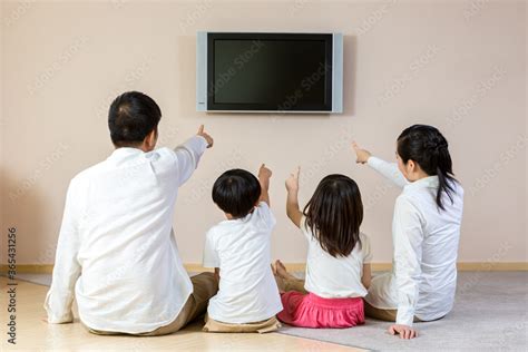 Happy family watching TV at home Stock Photo | Adobe Stock