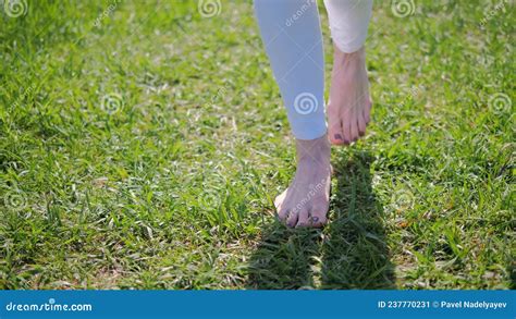 Close Up Naked Bare Feet Of A Woman Walking On Green Grass In Summer