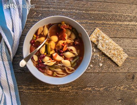 Bowl Of Minestrone Soup On Natural Table With Stone Ground Crackers Top