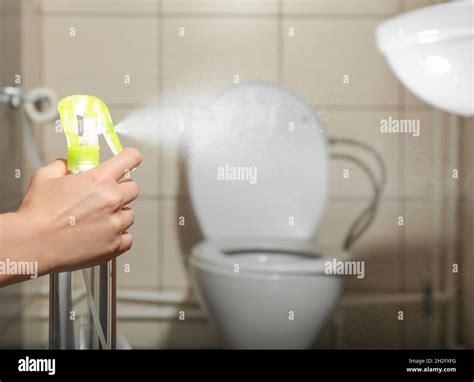 Woman spraying air freshener in bathroom Stock Photo - Alamy