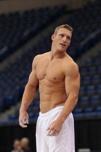 A Man Without A Shirt Standing In Front Of A Basketball Court With His