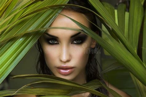 Beautiful Woman Hiding Behind Palm Leaves