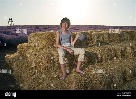 Portrait Of A Barefoot Boy In A Sleeveless Shirt And Trousers With