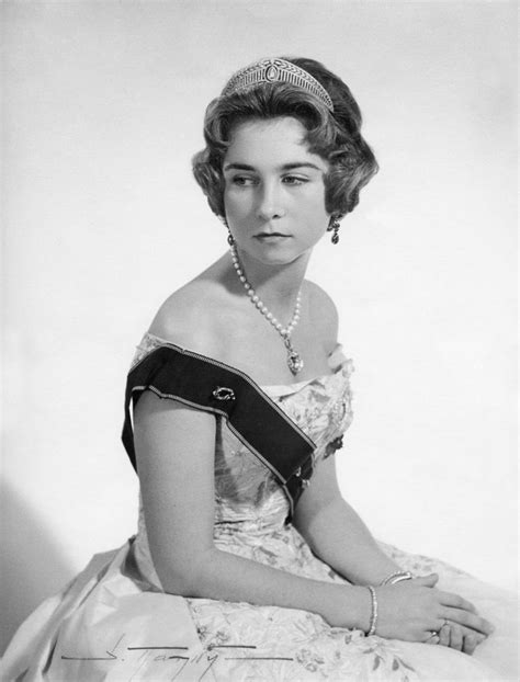 An Old Black And White Photo Of A Woman In A Dress With Pearls On Her Head