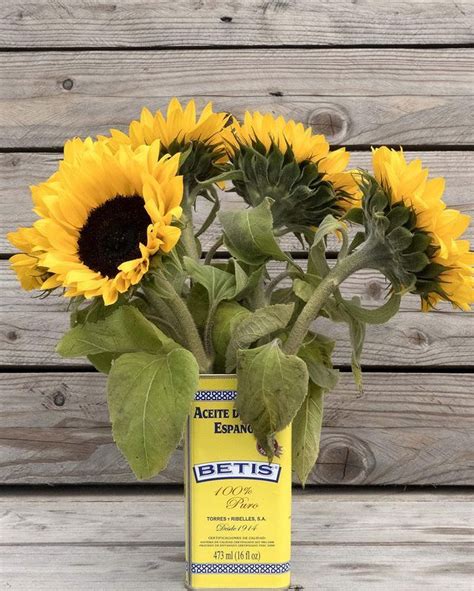 A Vase Filled With Sunflowers On Top Of A Wooden Table