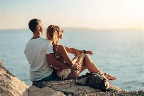 Vista Traseira De Um Casal Apaixonado Est Sentado Em Uma Rocha Do Mar