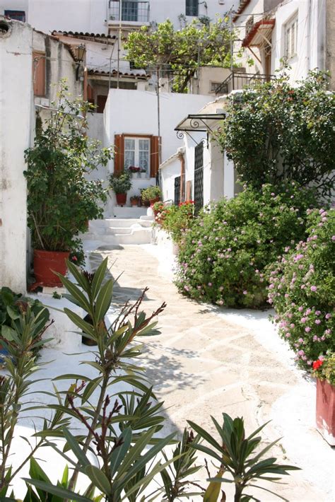 An Alley Way With Potted Plants And Flowers On Either Side In Front Of