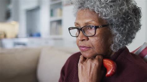 Thoughtful Senior African American Woman Holding Walking Stick Sitting