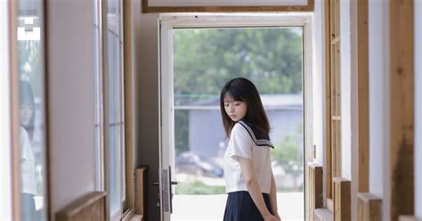 Woman In White Long Sleeve Shirt And Black Skirt Standing Beside Glass Window Photo Free