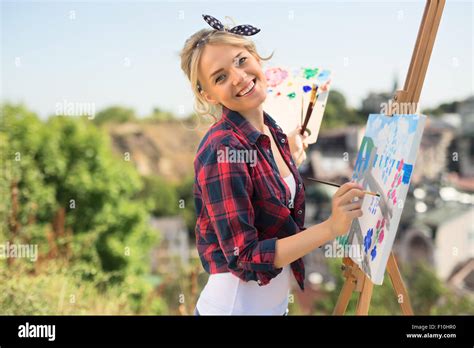 Beautiful Blonde Woman Artist Paints A Colorful Picture Stock Photo Alamy